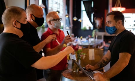 People wear masks as they show proof of vaccination at a restaurant in Philadelphia.  