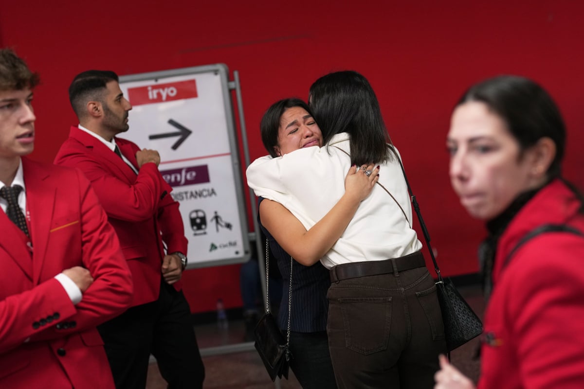 Iryo railway employees embrace tearfully after a minute of silence at the station