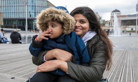 Kavita Tripathi sits on a bench with a child on her knee
