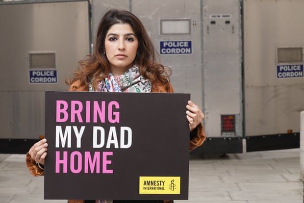Roxanne Tahbaz holding up a placard reading ‘Bring My Dad Home’ in pink and white lettering on a black background