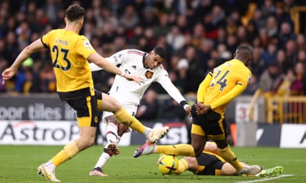 Marcus Rashford perce son tir à travers une foule de joueurs des Wolves pour marquer pour Manchester United