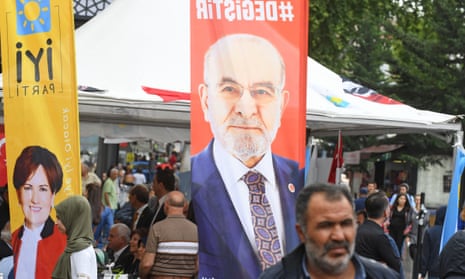 People walk in front of banners of two of Turkey’s presidential candidates – Temel Karamollaoğlu, right, and Meral Aksener, left