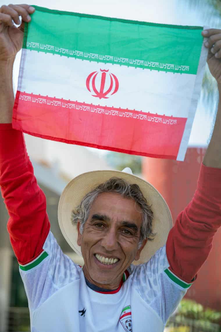 Happy man in hat holds Iranian flag aloft