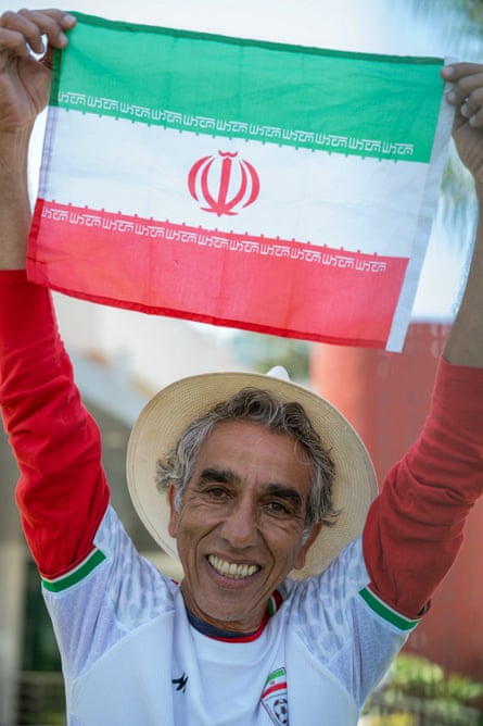 Happy man in hat holds Iranian flag aloft