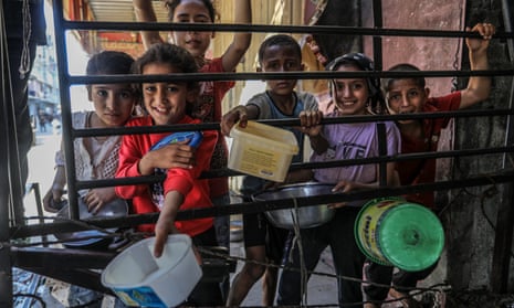 Palestinians in Gaza queue for hot food