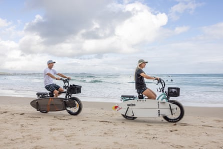 Australian surfers Josh and Sierra Kerr ride along the sand at Greenmount Beach, Coolangatta