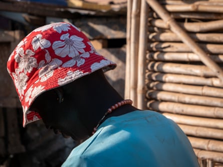 A young African man in a flowery bucket hat seen from behind