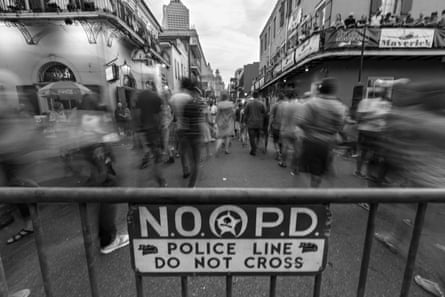 Pedestrians walk near a police barricade on Bourbon Street in New Orleans.