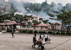 Papuans carry their belongings as they flee after protesters torched Buruni market, Wednesday, Aug. 21, 2019.
