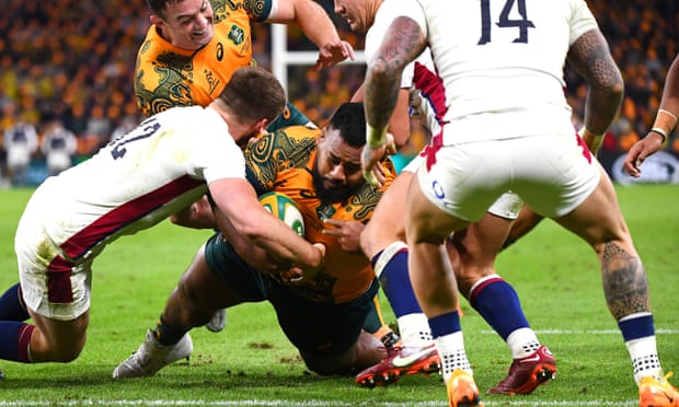 Australia’s Taniela Tupou dives for the tryline to score despite the efforts of England defenders