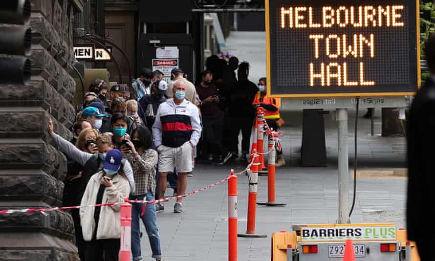 How Australia went from Covid-zero to Covid-central in just a few months | Australia news 4 People wait in line at a walk-in Covid-19 testing site at Melbourne Town Hall.