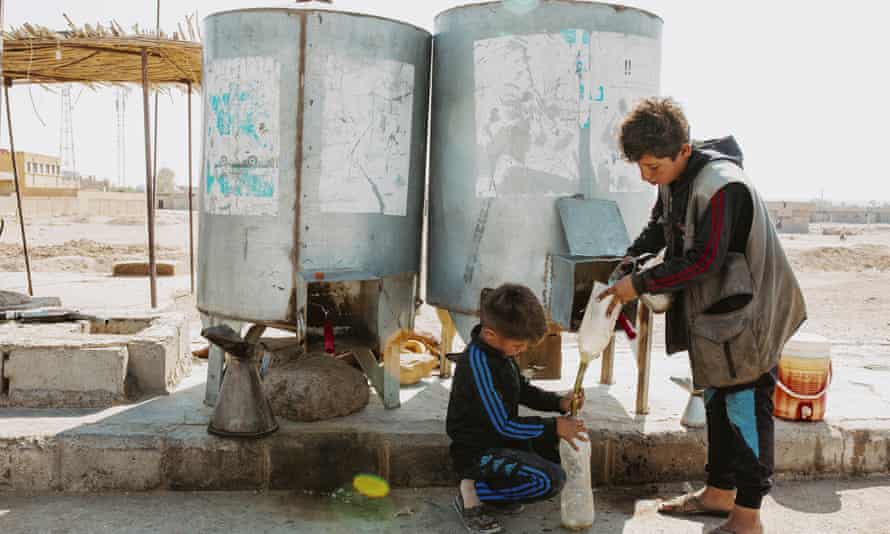 Haseke ilindeki Shaddadi kasabası yakınlarındaki bir benzin istasyonunda çalışan iki genç çocuk.