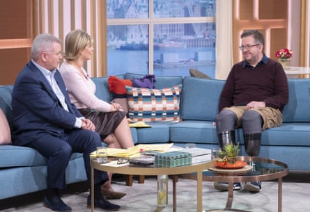 Neil Hopper sitting on one side of a sofa in a TV studios, being interviewed by Eamonn Holmes and Ruth Langsford, who are sitting on the other side of the sofa