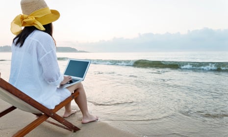 Woman using laptop at the beach.