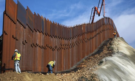 A construction crew works on new sections of the US-Mexico border barrier.