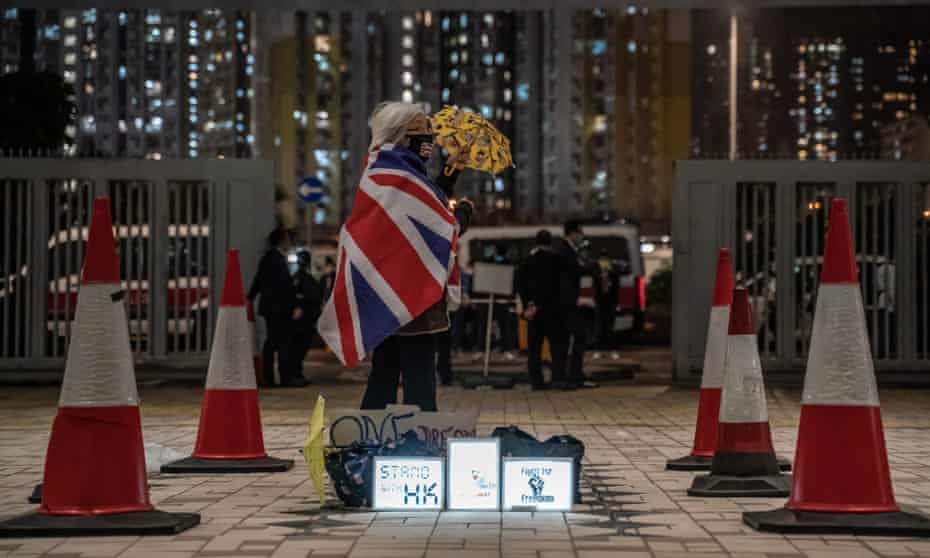 An activist known as Grandma Wong, holds up a yellow umbrella outside the West Kowloon Magistrates Courts during the forth day of a bail hearing for 47 opposition activists charged with violating the city’s national security law.