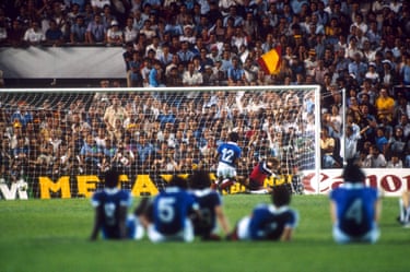 The France team watch from the centre circle as Alain Giresse sends West Germany goalkeeper Harald Schumacher the wrong way to score