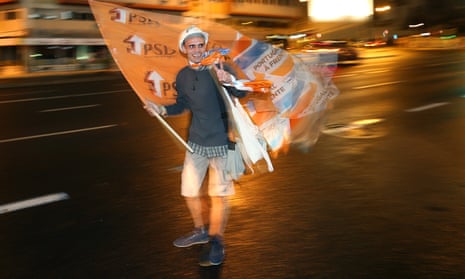 A center-right ruling coalition supporter celebrates after the election victory.