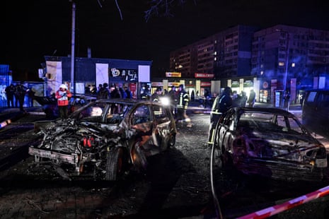 Firefighters seen in the distance near wrecked cars