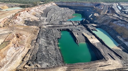 Aerial shot of an open-cut mine with green pools of water
