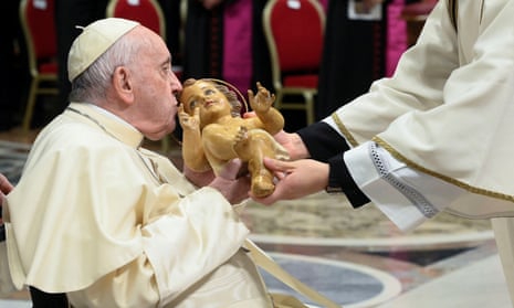 Pope Francis kisses a statue of baby Jesus as he celebrates Christmas Eve mass in St. Peter's Basilica at the Vatican.