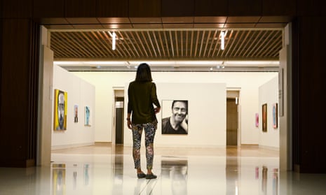 A person stands inside an exhibition space in the National Portrait Gallery
