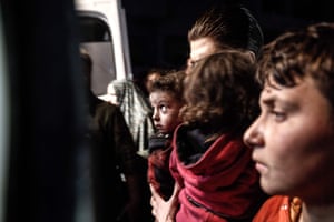A Syrian civil defence volunteer carries an injured girl following an explosion in the rebel-held city of Idlib which killed at least 13 civilians in the jihadist-held city.