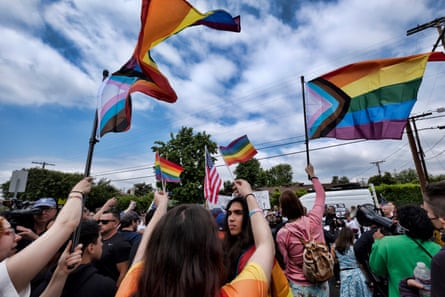 Counter-protesters wave Pride flags as Los Angeles police officers separate them from other protesters at Saticoy elementary school in North Hollywood, Los Angeles.