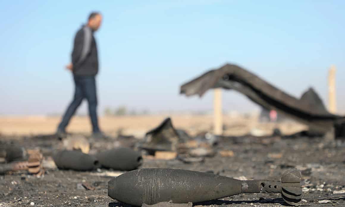 A man walks past mortars on the ground