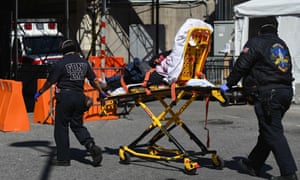 Paramedics roll a stretcher with a patient to Brooklyn hospital center emergency room on 27 March 2020 in New York City.