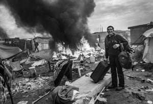 France, October 2016 An Afghan refugee stands with his belongings by his tent