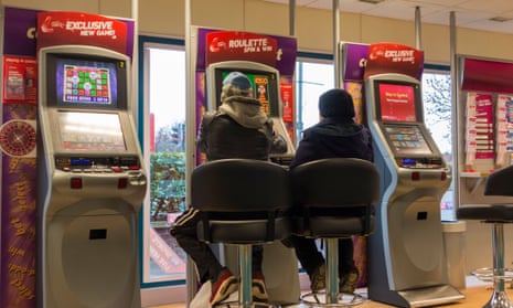 Man and woman at fixed odds gaming machines