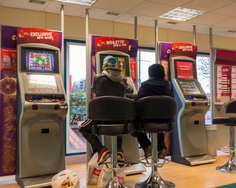 Man and woman at fixed odds gaming machines