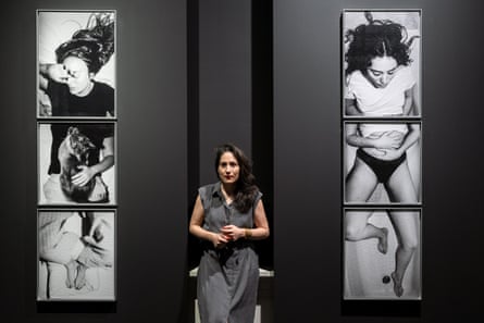 Laia Abril standing between two vertical triptychs of women suffering pain