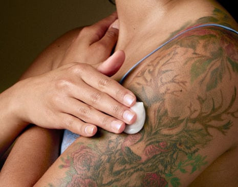 Woman cleansing/padding her newly tattooed arm