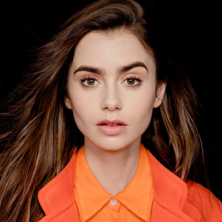 Lily Collins looking at camera wearing orange Christopher Esber