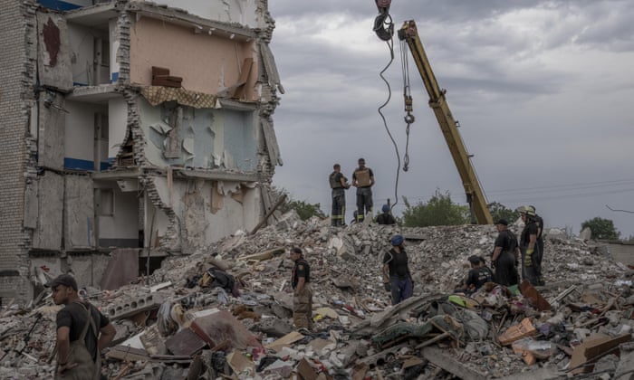 Rescue workers stand on the rubble in the aftermath of a Russian rocket that hit an apartment block in Chasiv Yar, Donetsk region, eastern Ukraine on Sunday.