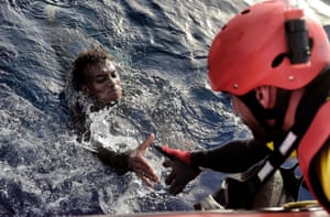 A migrant is rescued from the mediteranean sea by a member of Proactiva Open Arms NGO