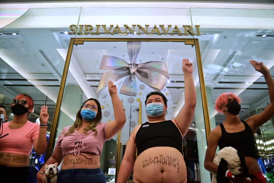 Protesters make the three-finger salute during a 'cultivation protest' outside a boutique owned by a member of the Thai royal family in Bangkok on December 20.