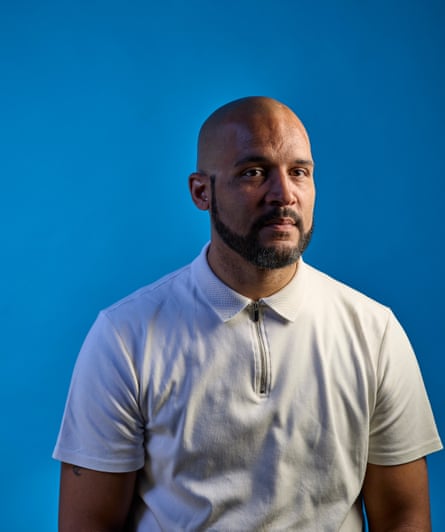 A man of colour wearing a white top on a blue background