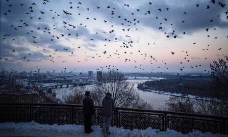 Crows fly in the cloud-dotted skies over central Kyiv