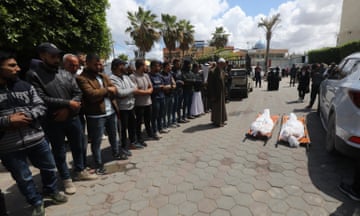 Relatives receive the bodies of those killed in Israeli strikes at al-Aqsa hospital