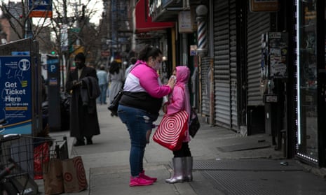 A woman adjusts a child’s face mask in New York, New York. More than 100 cases of the unusual illness have now emerged in at least six countries. 