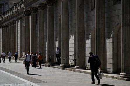 People pass the Bank of England building in London.