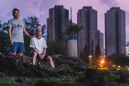 Yip Shun-Ting Carbon and his father Yip Ka-kui in front of the fire-ravaged Wang Fuk Court in Hong Kong. Both had spent decades in the estate where Yip grew up, met his wife and built a life; the deadly blaze last November claimed his mother and destroyed their family home.