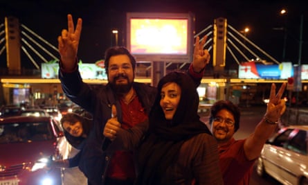 People flash the “V for Victory” sign as they celebrate on Valiasr street in northern Tehran.