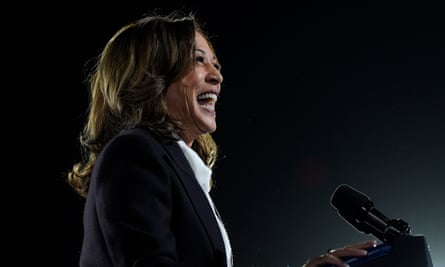 side-profile of woman wearing black jacket and white shirt laughing behind microphone