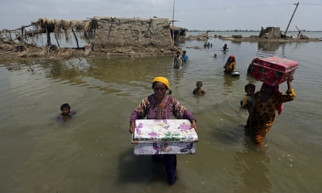 Women carry belongings salvaged from their flooded homes in the Qambar Shahdadkot district of Sindh Province of Pakistan.