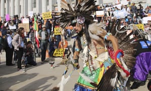 A supporter of the Bears Ears and Grand Staircase-Escalante national monuments dances with a headdress during a rally on Saturday in Salt Lake City.