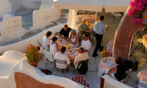 Diners in a picturesque restaurant with ocean view, in Oia.